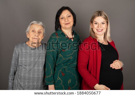 Picture of women generations in a family - pregnant granddaughter, mother and grandmother - indoor photography