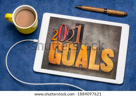 2021 goals - New Year resolutions concept - word abstract in vintage letterpress wood type blocks on a digital tablet with coffee