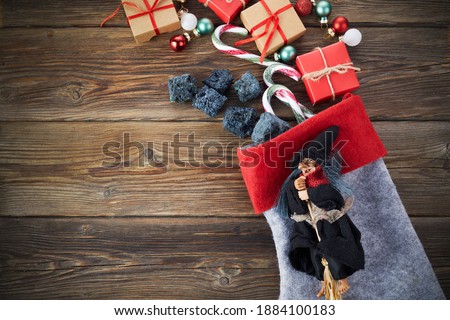 The Befana with sweet coal and candy on wooden background. Italian Epiphany day tradition. Royalty-Free Stock Photo #1884100183