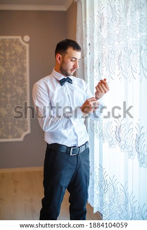 Young groom dressed in his home. Handsome man in wedding suit smile. Groom's morning