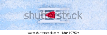 Happy New Year. white sled with a red heart and and snow on a blue background. New year and merry Christmas concept.
