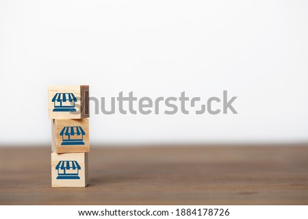 Franchise business marketing system concept. Service store network strategy. shopping store icon on wooden cube.
