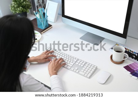 Over head shot of  woman graphic designer working with her computer at her creative workspace.