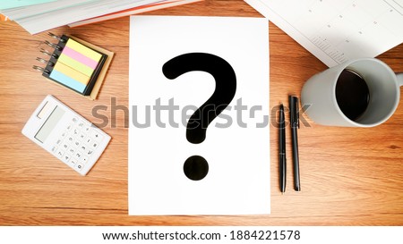 Desk with question mark. The concept of business and education with curious and unknown unstable stress.
