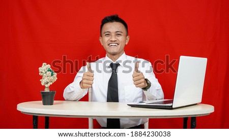 Asian business man ok gesture with laptop on table