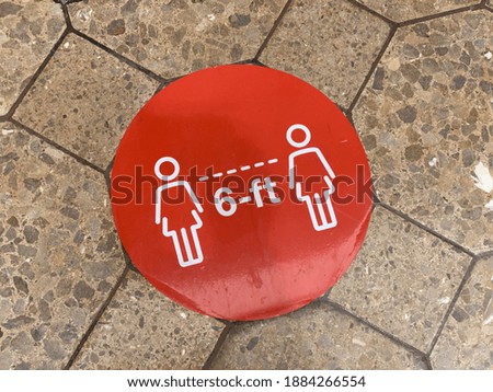 Red stop sign like COVID contact related floor sign at retail shopping mall entrance