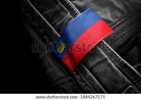 Tag on dark clothing in the form of the flag of the Liechtenstein.