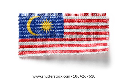 Malaysia flag on a piece of cloth on a white background.