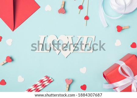 Above view photo of envelope pins little hearts and wrapped present box on light blue backdrop