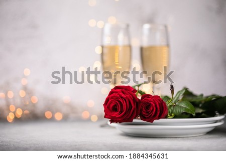 Valentines dating table setting  red roses and champagne glasses on concrete background. Valentine 's greeting card - Image