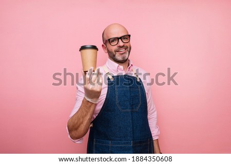 Smiling bald mature man with coffee in recyclable cardboard cup