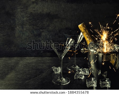 Champagne with two glasses and sparklers decoration. Vintage style toned picture