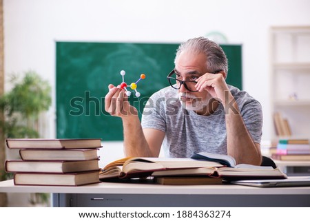 Old male physicist student in the classroom Royalty-Free Stock Photo #1884363274