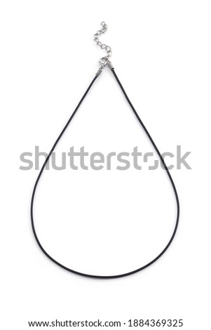 Subject shot of black jewelry cord for pendants made as rubber rope with lobster clasp and extension chain. The necklace cord is isolated on the white background.  Royalty-Free Stock Photo #1884369325