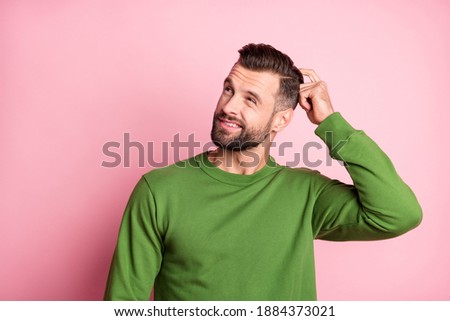 Photo portrait of unsure clueless man looking empty space wearing green jumper isolated pastel pink color background Royalty-Free Stock Photo #1884373021