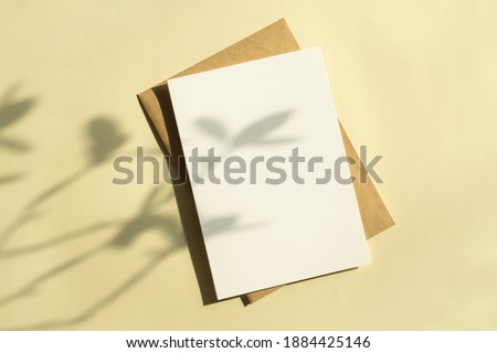 Card mock-up with plant shadows on a yellow background