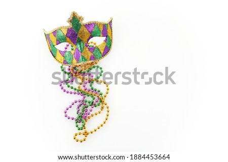 Mardi gras mask and colorful beads on white background