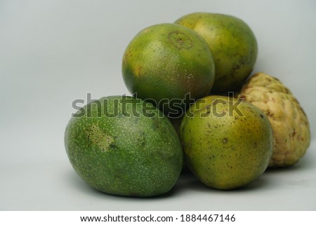 Heaps of fruit consisting of srikaya, avocado and oranges. Selective focus.