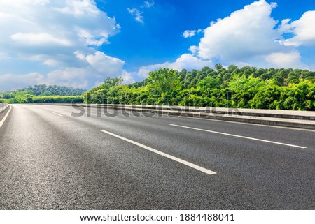 Asphalt road and green mountain under blue sky.Road and mountain background.