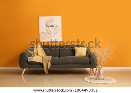 Comfortable sofa near color wall in room