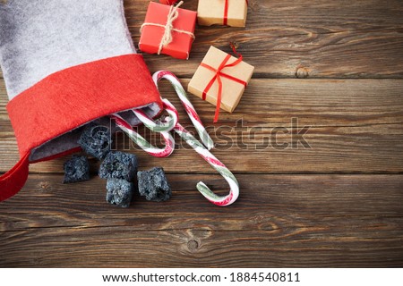 The Befana sock with sweet coal and candy on wooden background. Italian Epiphany day tradition. Royalty-Free Stock Photo #1884540811
