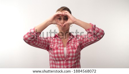 Blond hair young woman making heart sign with her hands on white background. Love support show, volunteering, donation, kindness concept.
