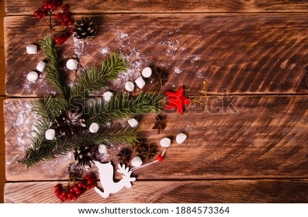 red viburnum. Christmas cones and branches on wooden boards with marshmallows. snowflakes and deer figurines