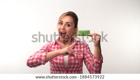Young woman holding a green box in her hand, isolated on a white background. The woman draws attention to the green box. Creative people can put the product they want into the woman's hand.
