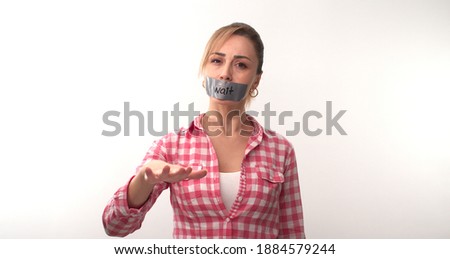 The young woman who wanted to give a social message taped her mouth, the tape on her mouth says wait. Message given silently. Wait.
