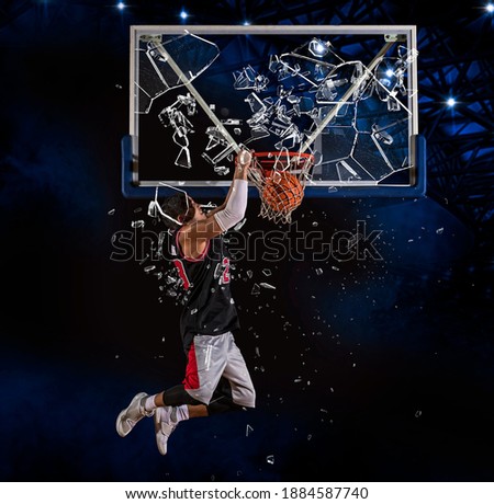 Shattered backboard.  Basketball player players in action. Basketball concept on dark background Royalty-Free Stock Photo #1884587740