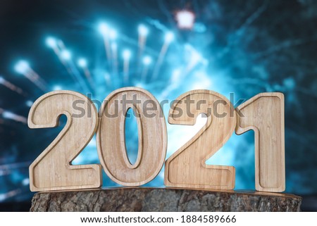 Happy New Year Wooden Number 2021 as text with fireworks background.