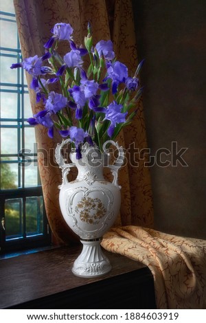 Still life with bouquet of irises in old vase