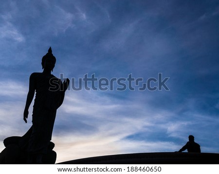 the big black buddha with blue sky background and shadow of a man