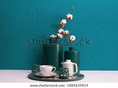 breakfast with coffee on a tray, candlesticks, dry cotton plant in vases on a blue background on the table