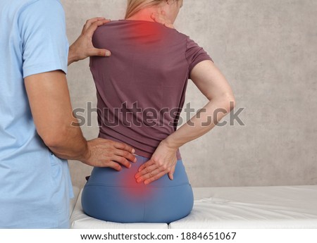 Woman suffering from neck and low back pain during medical exam. Chiropractic, , Physiotherapy. Posture correction