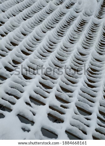 Steel grid covered with snow and ice buildup-abstract background closeup