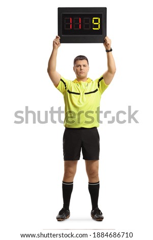 Full length portrait of football referee holding a substitute board isolated on white background