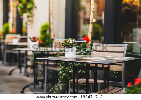 Outdoor empty coffee and restaurant terrace with potted plants tables and chairs in london indie and hipster style Royalty-Free Stock Photo #1884717181