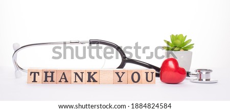 Gratitude expressing to all doctors. Close up panoramic frame view photo of doctor tools red small heart and wooden blocks with inscription isolated white backdrop