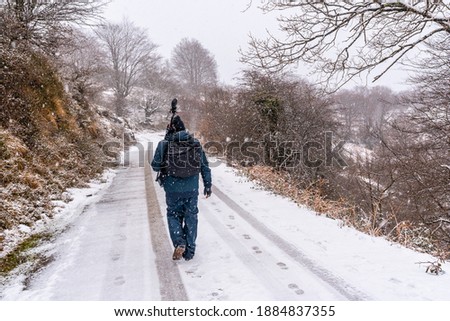 A young photographer on the snowy road of Mount Aizkorri in Gipuzkoa. Snowy landscape by winter snows. Basque Country, Spain