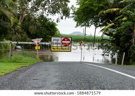 A warning sign that the bridge is underwater and flooding has closed the road in tropical North Queensland, Australia, due to heavy rain.
