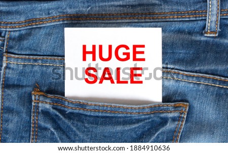 Text Huge Sale on white paper in the pocket of blue denim jeans. Can be use as marketing concept