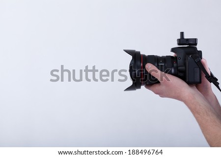Hands holding a digital camera on isolated background
