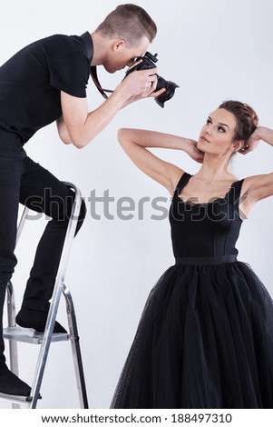 Photographer and woman during photosession in evening clothes Royalty-Free Stock Photo #188497310