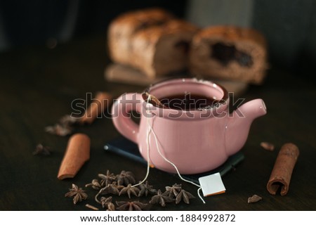 A cup of teabag with grated bread on a wooden chopping board decorated with cinnamon and star