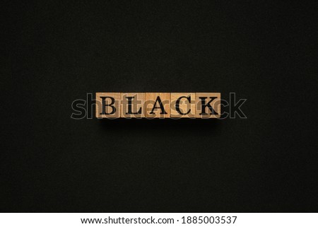 Creative concept 'Black' word on wooden cube. Flat lay view concept on black background.