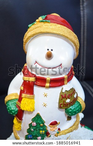 Smile snowman in snow wearing red hat and scarf.Smile snowman in snow wearing  green glove.snowman doll.