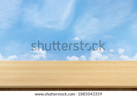 Empty wooden board table with blurred background. Perspective brown wood over blur the sky and clouds - can be used to display or edit your products, simulate to showcase them.