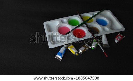 View of water coloring tools with black background.  Dark theme photography.