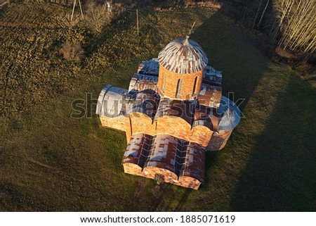 Top view of the old stone church on the background of the autumn landscape. Aerial photography